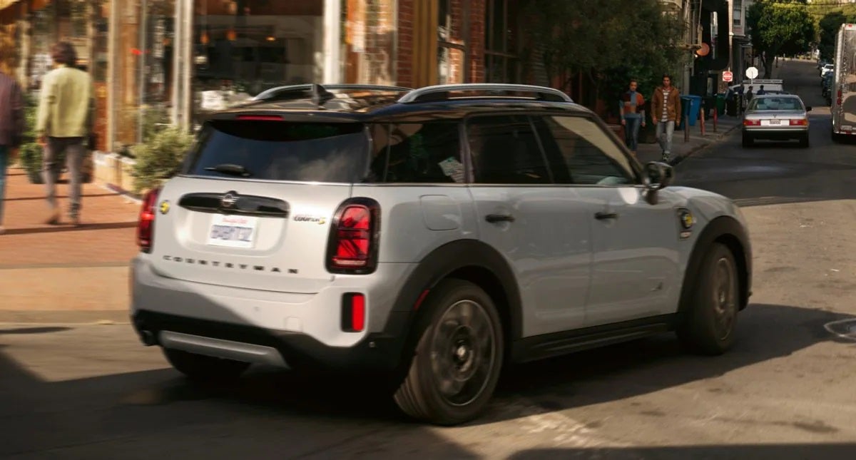 The MINI Cooper SE Countryman PHEV turning a corner in the city. MINI of Peabody in Peabody MA