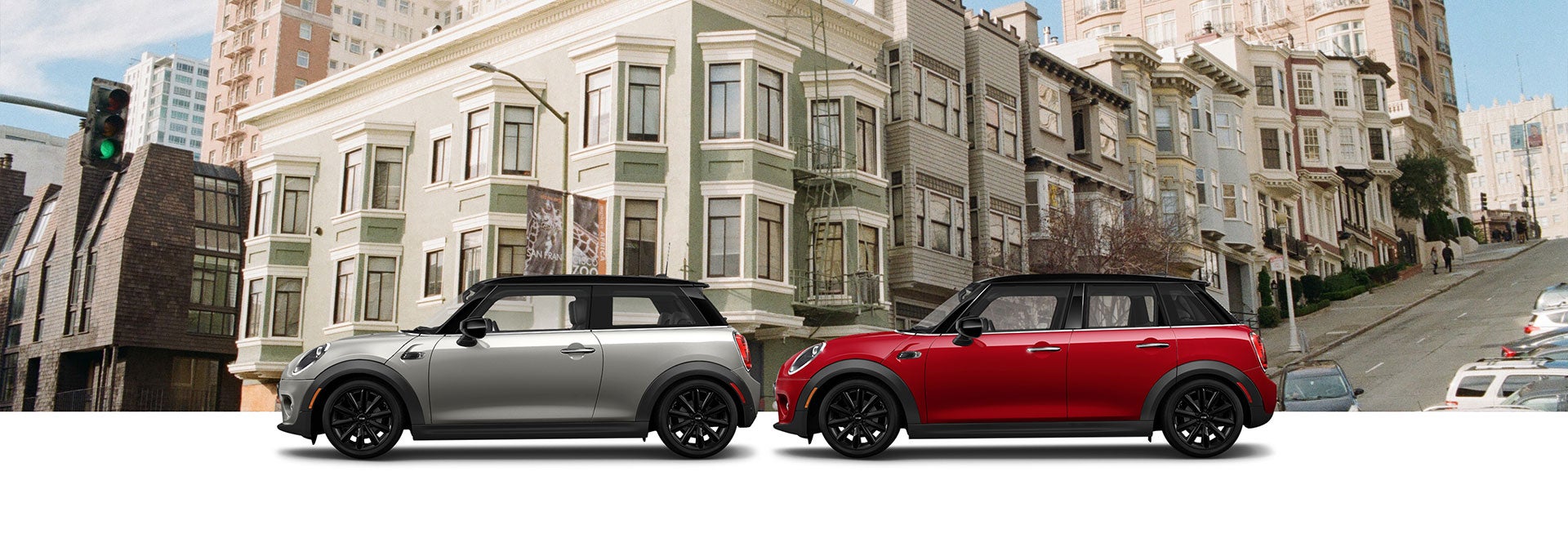 Grey Oxford Edition MINI Cooper 2 Door Hardtop and Red Oxford Edition MINI Cooper 4 Door Hardtop in front of cityscape | MINI of Peabody in Peabody MA