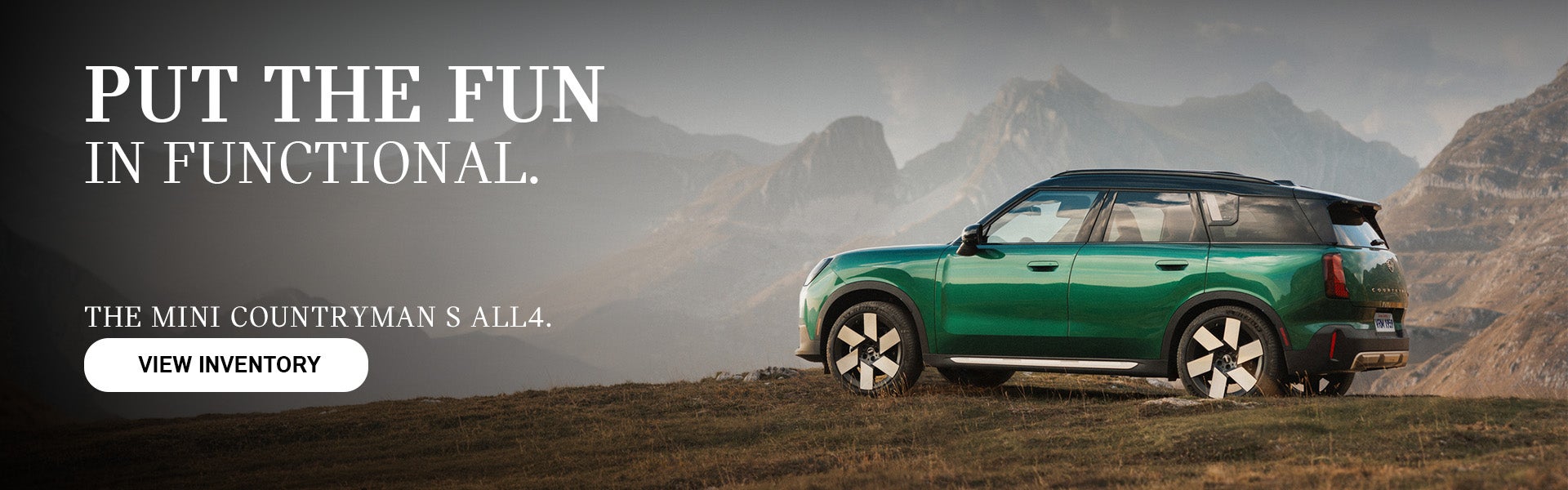 Green MINI Countryman S ALL4 parked on a grassy mountain overlook with rugged peaks in the background. Promotional text reads