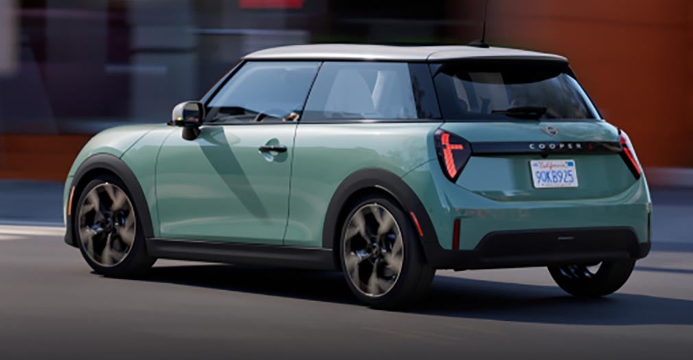 Angled view of the MINI Cooper S 2 Door parallel parked in front of a purple building.