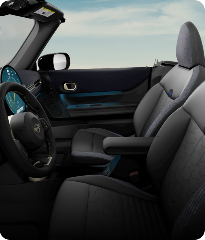 The front of the MINI Cooper S Convertible’s cabin, taken from the driver’s side, with a focus on the Sports Seats and steering wheel.
